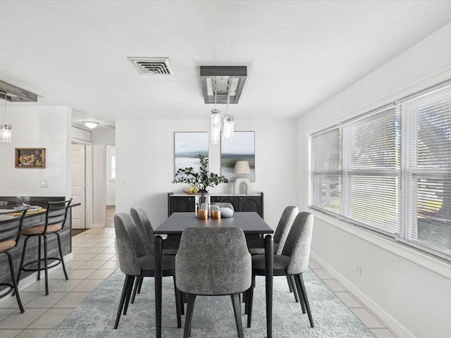 dining area featuring light tile patterned flooring, visible vents, and baseboards