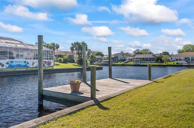 dock area featuring a lawn and a water view