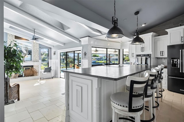 kitchen featuring white cabinetry, stainless steel oven, black fridge, lofted ceiling with beams, and backsplash