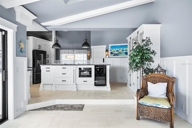 kitchen with black appliances, lofted ceiling with beams, white cabinets, hanging light fixtures, and beverage cooler