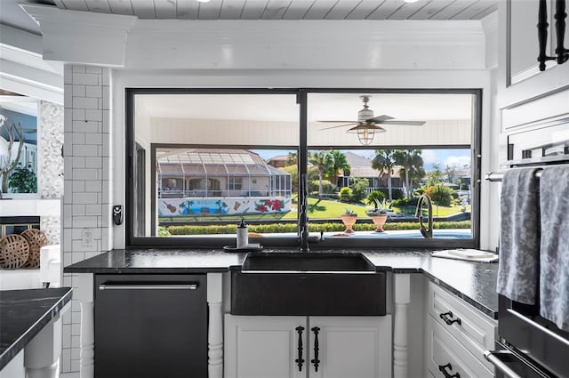 kitchen featuring white cabinetry, ceiling fan, stainless steel dishwasher, oven, and dark stone counters