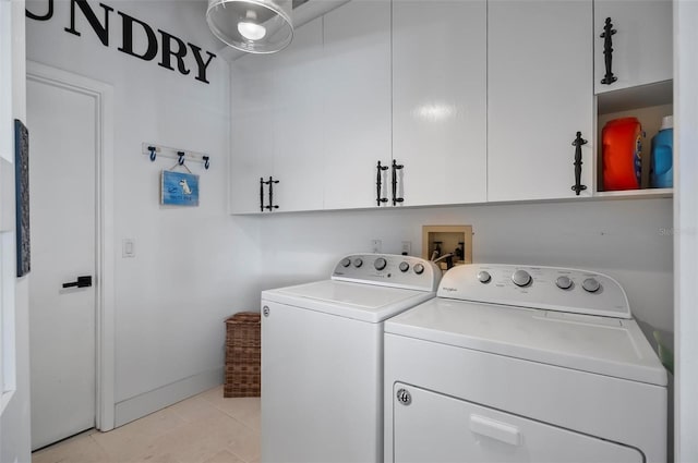 laundry area featuring cabinets, light tile patterned floors, and washing machine and dryer