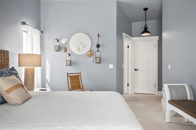 bedroom with high vaulted ceiling and light hardwood / wood-style floors