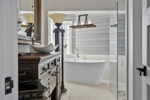 bathroom with vanity, a bathtub, and tile walls