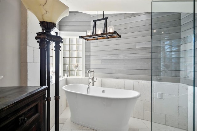 bathroom with a washtub and tile walls