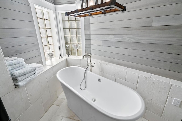 bathroom featuring a washtub and wooden walls