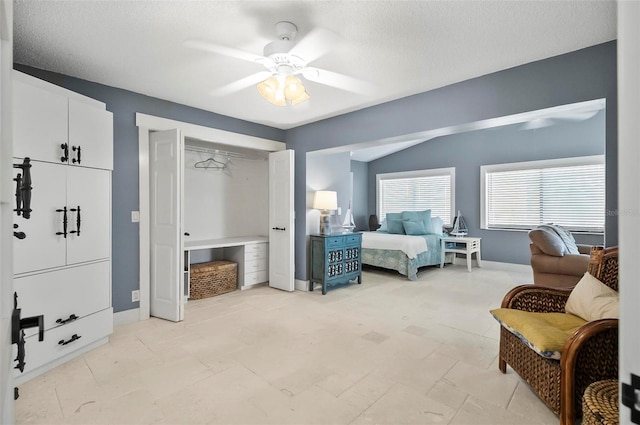 bedroom featuring vaulted ceiling, ceiling fan, a closet, and a textured ceiling