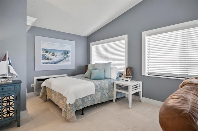 bedroom with light tile patterned floors, lofted ceiling, and a wall unit AC