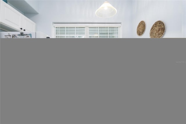 interior space featuring white cabinets and decorative light fixtures