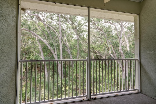 unfurnished sunroom with ceiling fan