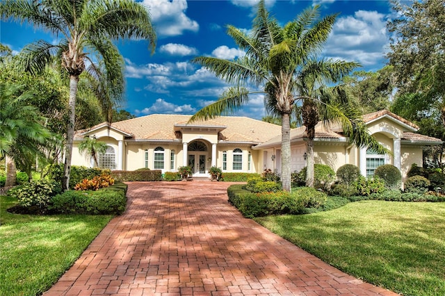 mediterranean / spanish-style house featuring french doors, a front lawn, and a garage