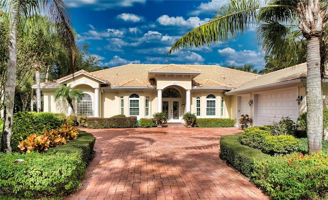 mediterranean / spanish-style home with french doors and a garage