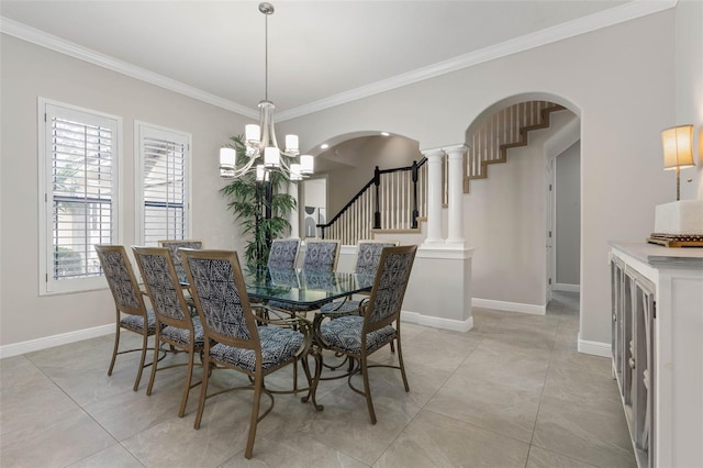 dining area with a chandelier, ornamental molding, and decorative columns