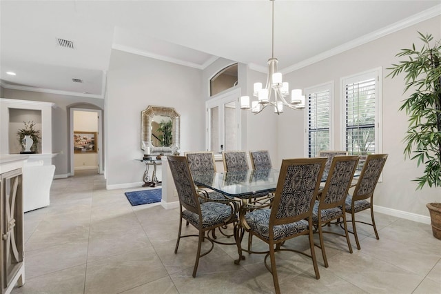 tiled dining area featuring ornamental molding and an inviting chandelier