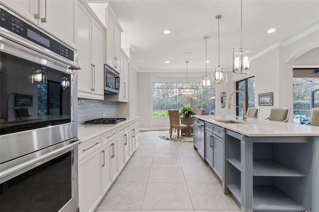 kitchen featuring sink, white cabinetry, a kitchen island with sink, and appliances with stainless steel finishes