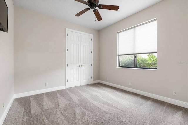 unfurnished bedroom with carpet flooring, ceiling fan, and a closet