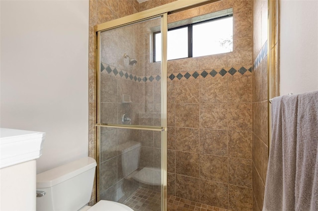 bathroom with toilet and a shower with shower door