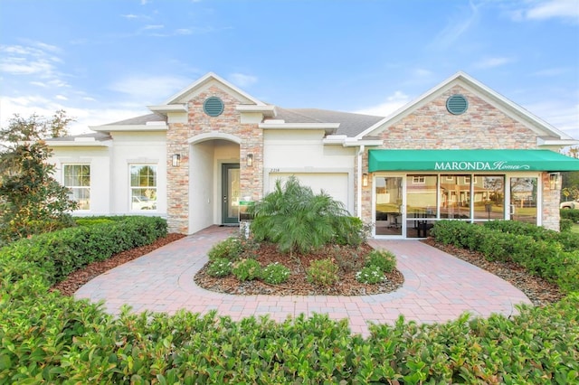 2214 Elegant Manor Cir, Edgewater, FL 32141 - view of front of house featuring stone siding, stucco siding, and an attached garage