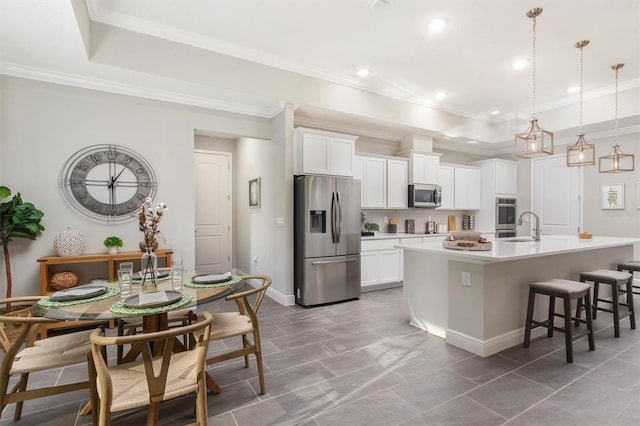 2214 Elegant Manor Cir, Edgewater, FL 32141 - kitchen with appliances with stainless steel finishes, an island with sink, white cabinets, a kitchen bar, and crown molding