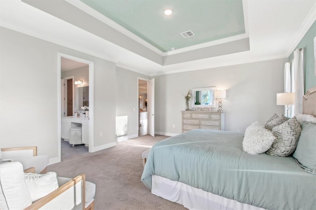 bedroom featuring a raised ceiling, crown molding, light carpet, and connected bathroom