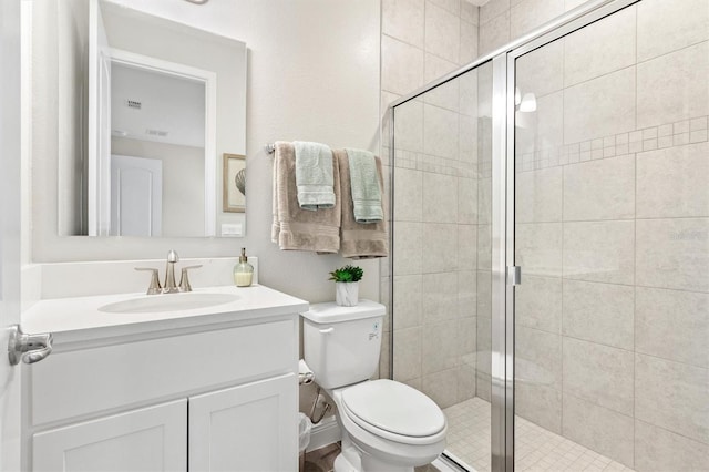 bathroom featuring vanity, an enclosed shower, and toilet