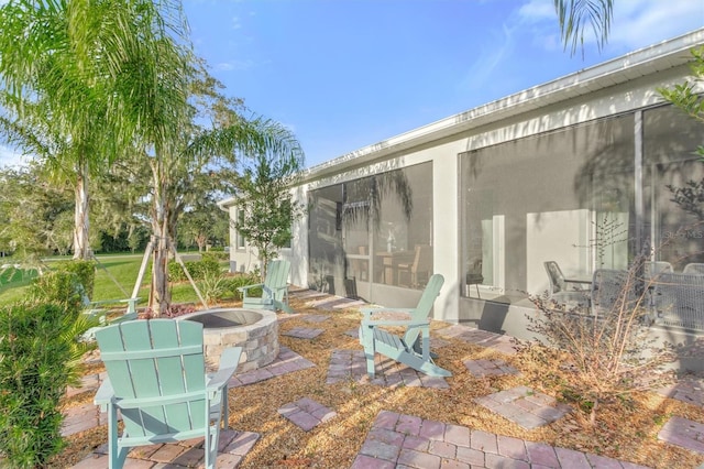 2214 Elegant Manor Cir, Edgewater, FL 32141 - view of patio / terrace with a sunroom and an outdoor fire pit