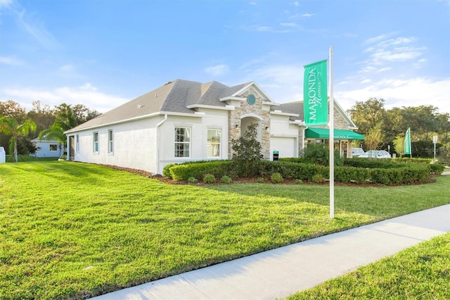 2214 Elegant Manor Cir, Edgewater, FL 32141 - view of front of property with a front yard, stone siding, and stucco siding
