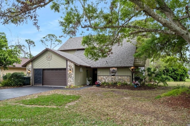 view of front facade with aphalt driveway, stone siding, and an attached garage