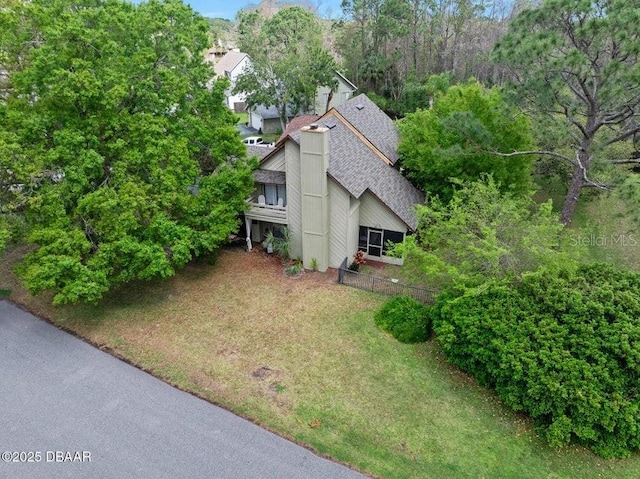 exterior space with a front lawn and roof with shingles