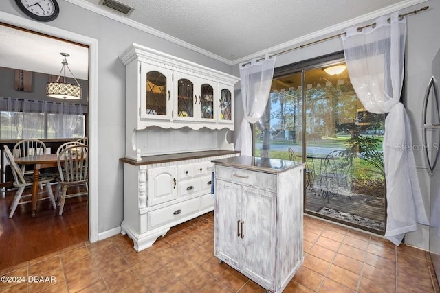 kitchen with visible vents, ornamental molding, white cabinets, glass insert cabinets, and a textured ceiling