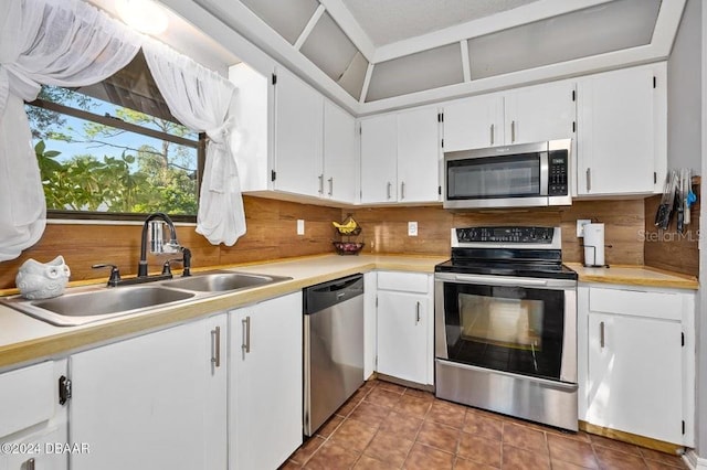 kitchen with a sink, decorative backsplash, appliances with stainless steel finishes, and light countertops