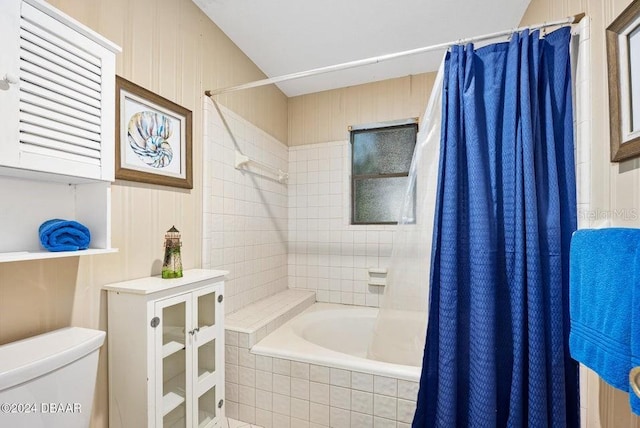 bathroom with toilet and tiled shower / bath