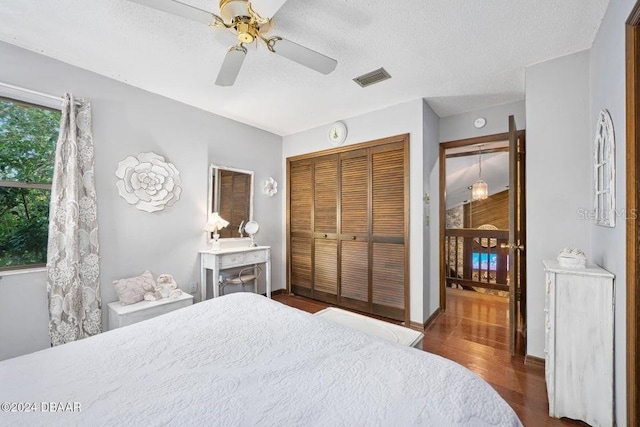 bedroom featuring visible vents, wood finished floors, a closet, and a textured ceiling