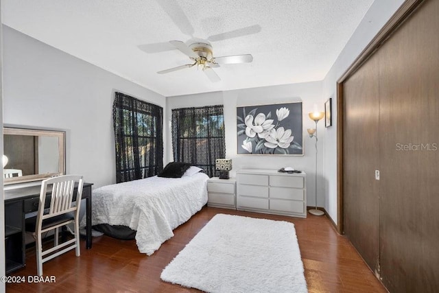 bedroom with ceiling fan, a closet, a textured ceiling, and wood finished floors