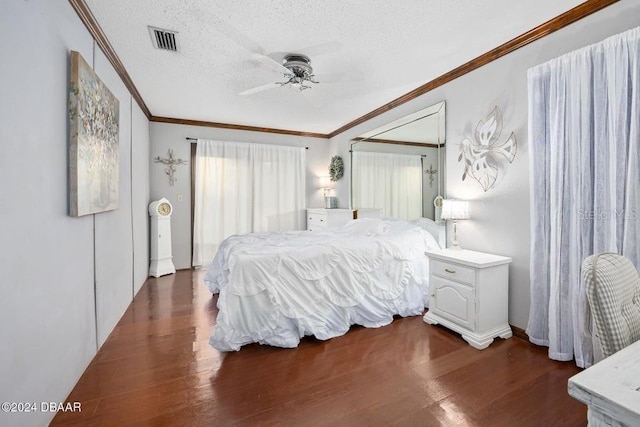 bedroom featuring visible vents, dark wood-style floors, and ornamental molding