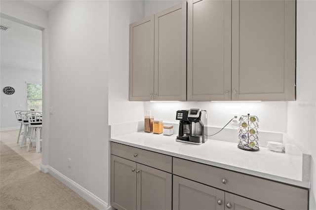 interior space with gray cabinets and light colored carpet