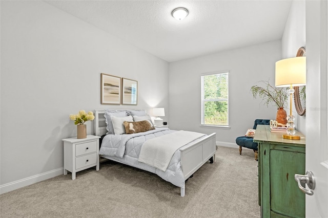 bedroom with a textured ceiling and light carpet