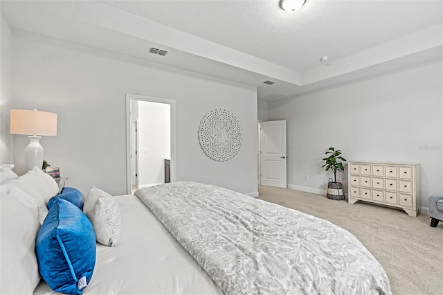 bedroom with light colored carpet and a textured ceiling