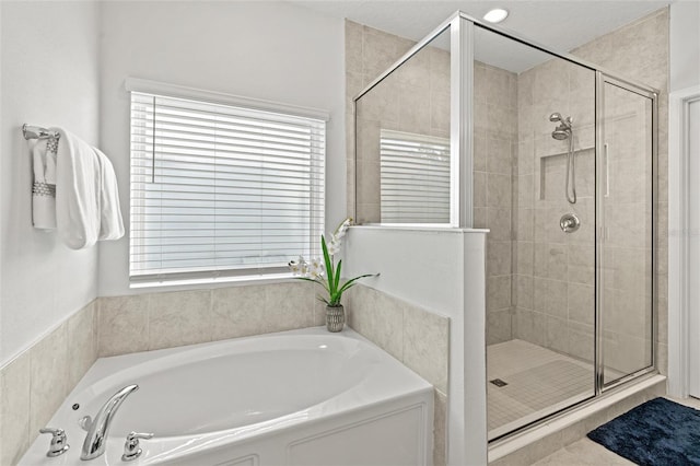 bathroom featuring plenty of natural light and plus walk in shower