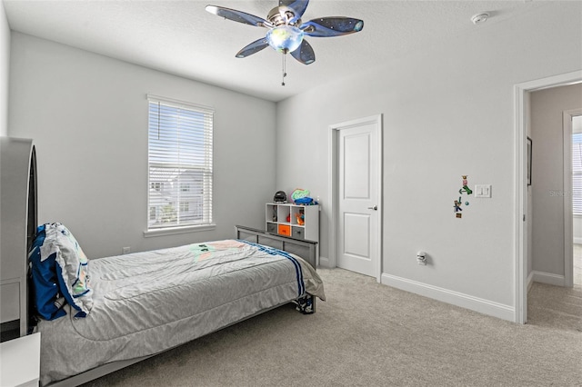 carpeted bedroom featuring ceiling fan and a textured ceiling