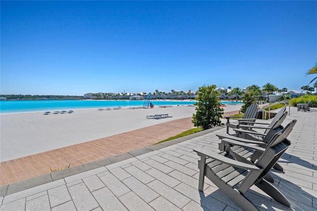 view of patio / terrace with a water view and a view of the beach