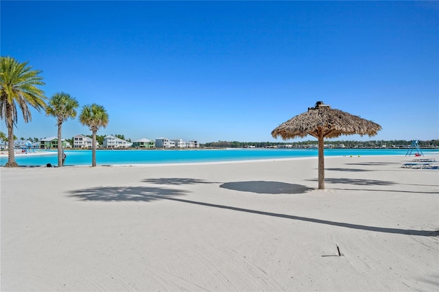 view of swimming pool featuring a view of the beach and a water view