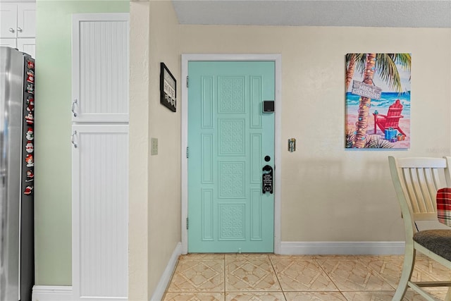 interior space with light tile patterned flooring and a textured ceiling