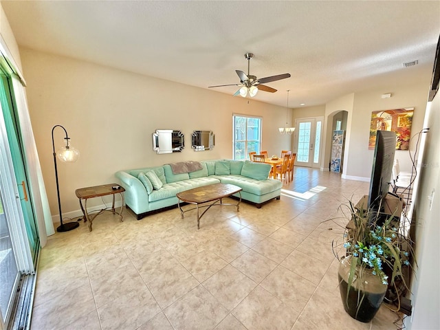 living room featuring ceiling fan, light tile patterned flooring, and a textured ceiling