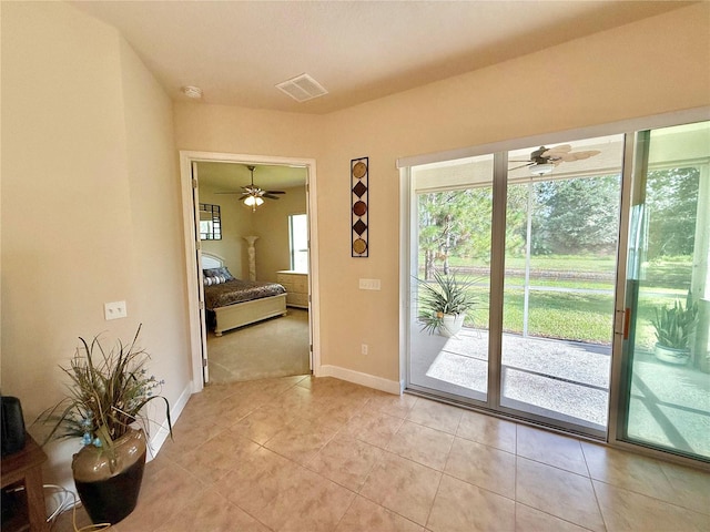 doorway with ceiling fan and light tile patterned flooring