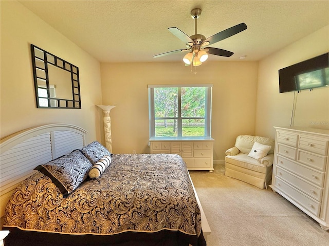 carpeted bedroom with ceiling fan and a textured ceiling