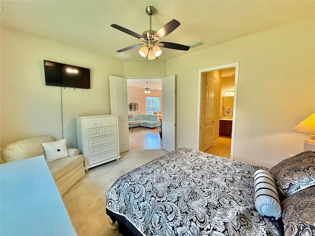 bedroom featuring connected bathroom, ceiling fan, and light carpet