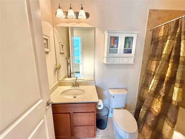 bathroom with tile patterned flooring, vanity, toilet, and curtained shower