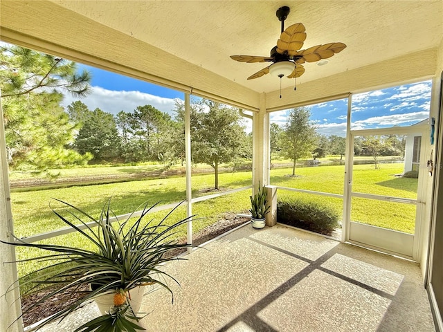 unfurnished sunroom with ceiling fan