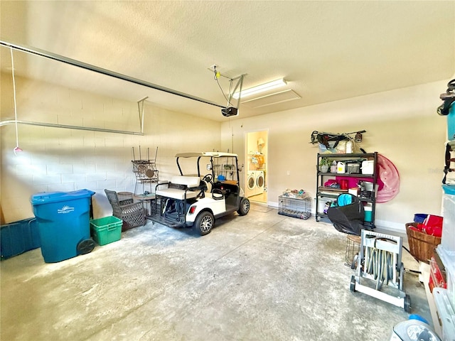 garage featuring independent washer and dryer and a garage door opener